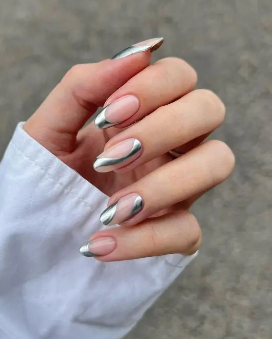 Eye catchy long almond nails with silver swirls on nude nails is adorable and looks very trendy