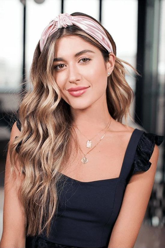lovely long wavy hair down paired with a beautiful pink satin headband for a feminine and very delicate look