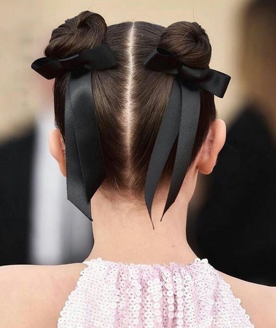 space buns with a sleek top and little black bows compose a super cute and lovely hairstyle