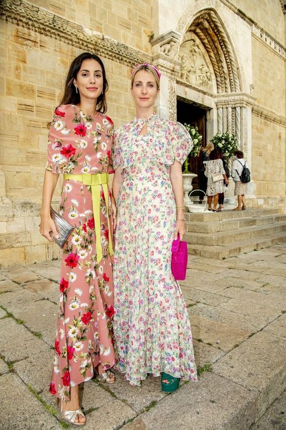 spring wedding guests wearing bold floral maxi dresses with high necklines, silver and green shoes and a hot pink and silver clutch