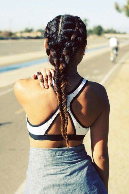 two side braids ending in a long low fishtail braid are a comfortable way to style long and thick hair for a workout