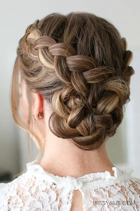 A Dutch braided bun with a bump on top and face framing hair is a cool and catchy solution to rock
