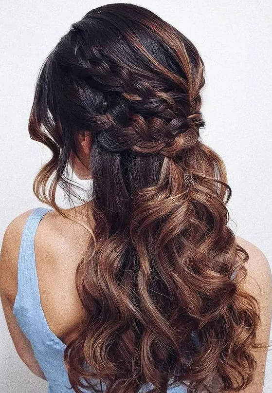 a beautiful boho half updo with a double braided halo and waves down, waves framing the face and caramel balayage that makes it cooler