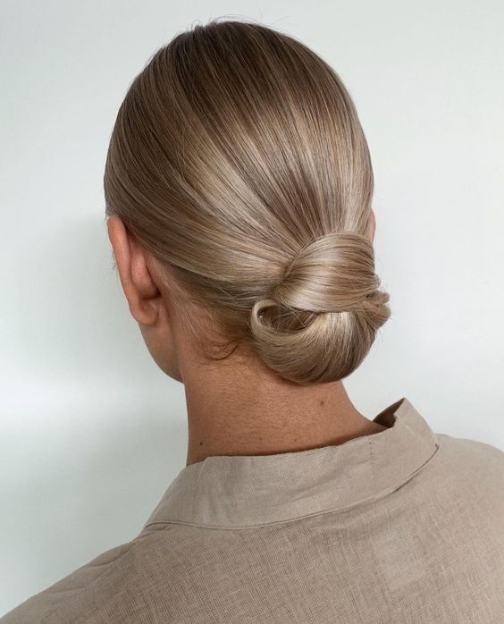 a beautiful sleek low knot with a sleek top is a chic wedding hairstyle for medium length hair