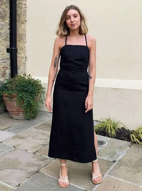 a black midi dress with a side slit and spaghetti straps plus white strappy sandals are a chic look for a summer brunch