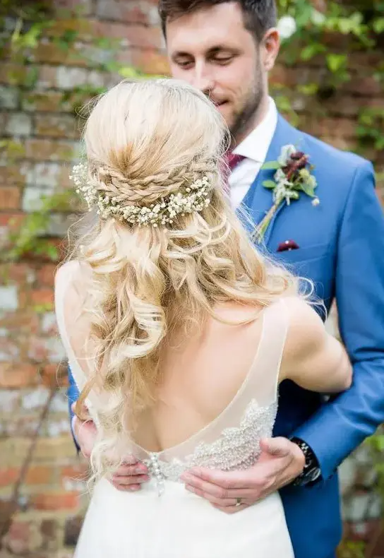 a braided half updo with a double halo and with baby’s breath looks sweet and will fit a rustic wedding