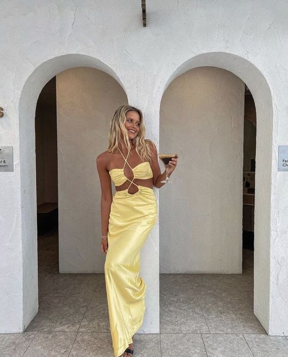 a bright yellow maxi dress with a crop top and a skirt on straps plus an open back is a very bold idea for a beach wedding