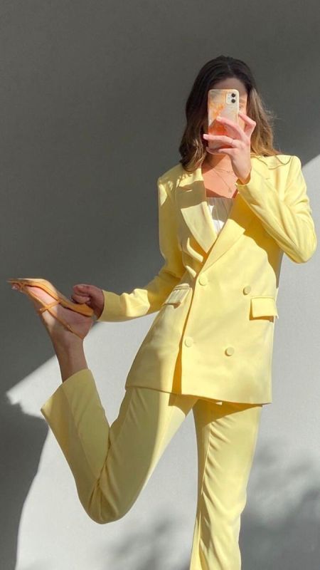 a bright yellow pantsuit with a white top and orange shoes are a colorful and vivacious look for graduation and not only