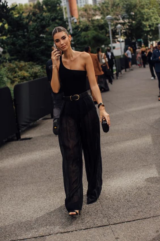 a chic and classy total black look with a one shoulder top, wideleg pants, black shoes, a small bag, a black belt with a gold buckle
