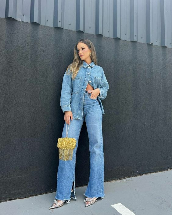 a classy double denim look with blue jeans, a blue denim shirt, bow heels and a gold bag with long fringe