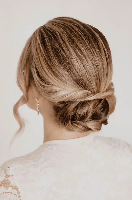 a cool and laconic low updo with twists and a braid and a sleek top, waves framing the face is very elegant