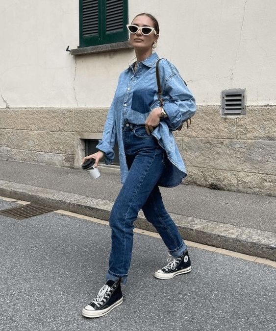 a fast everyday outfit with a blue denim shirt, blue mom jeans, black high top sneakers and a bag