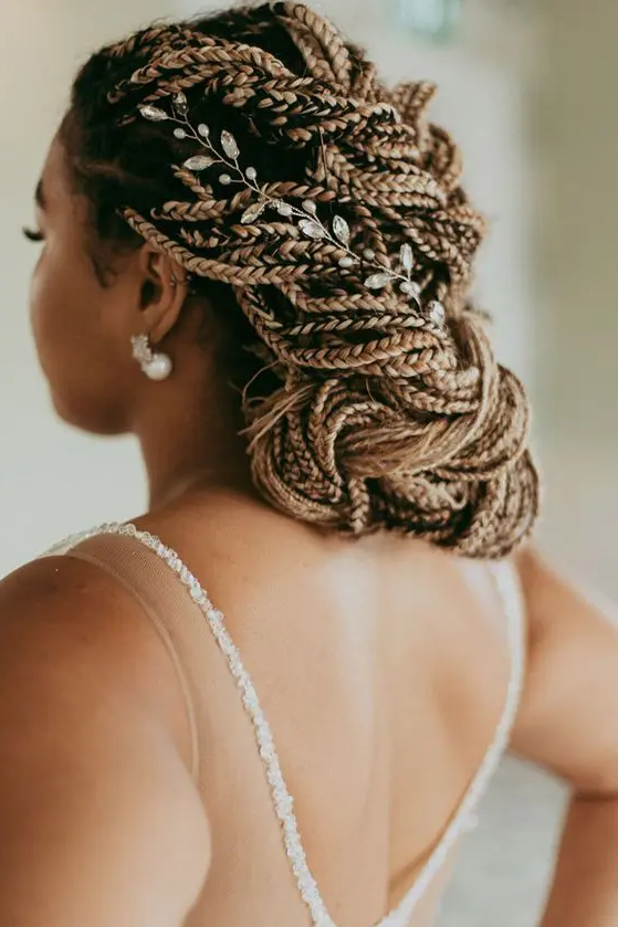 a fully braided low updo with a floral hair vine is a chic and cool idea for a wedding, it will catch all the eyes