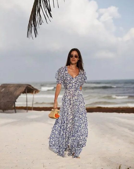 a gorgeous navy and white floral maxi gown with a deep neckline and short sleeves plus a small wicker bag