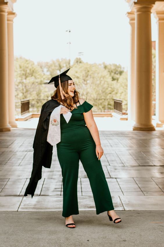 a green off the shoulder jumpsuit with a ruffle neckline, black shoes, a robe and a hat are a cool idea for a graduation party