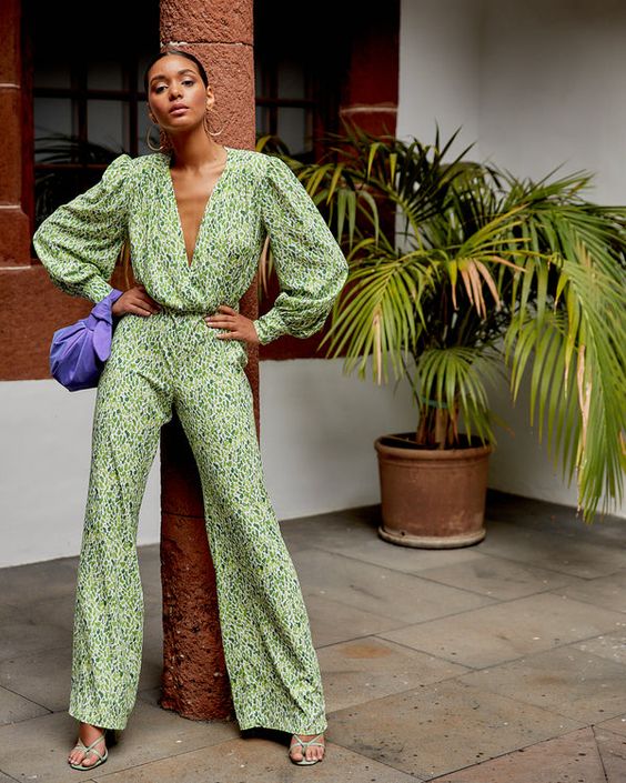 a green printed jumpsuit with a plunging neckline, green strappy shoes and a purple mini bag plus statement earrings