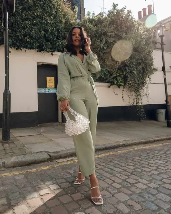 a light green jumpsuit, white strappy shoes, a bead bag for an effortless graduation look