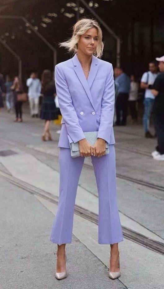 a lilac pantsuit with cropped flare pants, nude shoes and a blue bag is a cool idea for those who want some unusual and catchy color