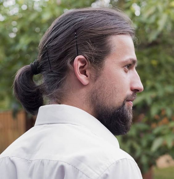 a man bob styled with a low ponytail and a couple of hairpins to keep the hair in place