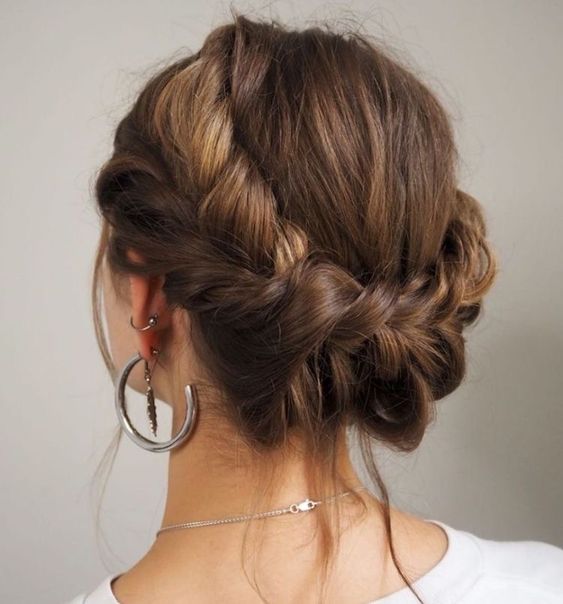 a messy braided loose updo with a bump on top and some hair down is a cool updo for medium length hair