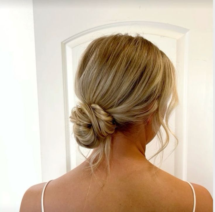 A messy low bun with face framing hair is a cool hairstyle for a wedding, for long and medium hair