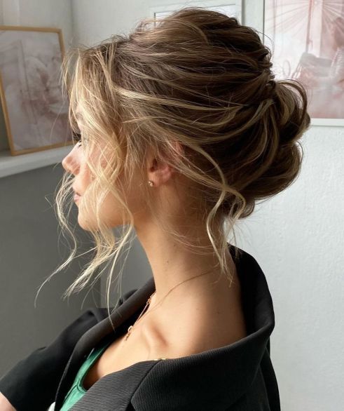 a messy wavy and textural updo with a bump on top and some face-framing hair is a stylish idea for a wedding