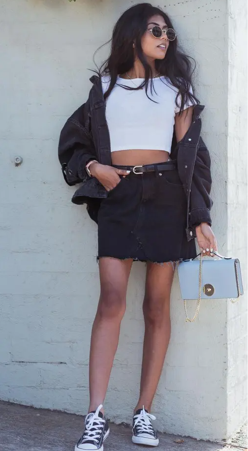 a monochromatic look with a white crop top, an oversized denim jacket, a mini skirt, black sneakers and a necklace