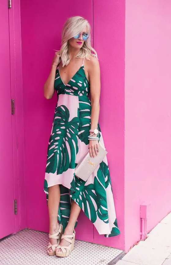 A pink midi dress with a tropical print, an asymmetrical skirt, a V neckline, spaghetti straps, wedges and a metallic clutch