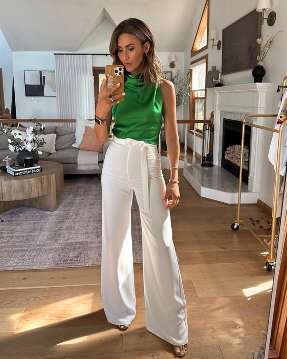 a pretty and bold look with a green satin high neck top, white palaezzo pants, nude shoes and some jewelry is a more relaxed idea