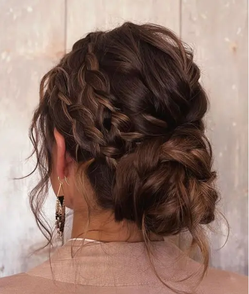 a pretty and messy braided low bun with twi side braids and hair down is a cool and catchy idea for a party look