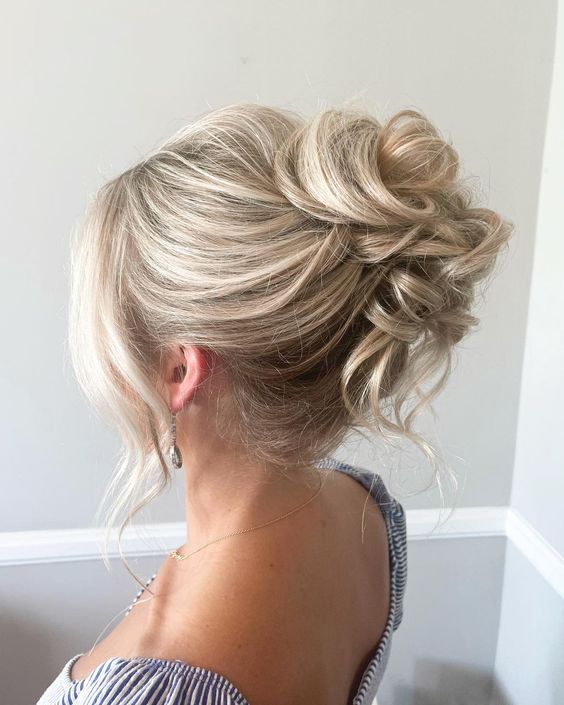 a pretty curly updo with a bump on top and face-framing hair is a lovely hairstyle for a wedding