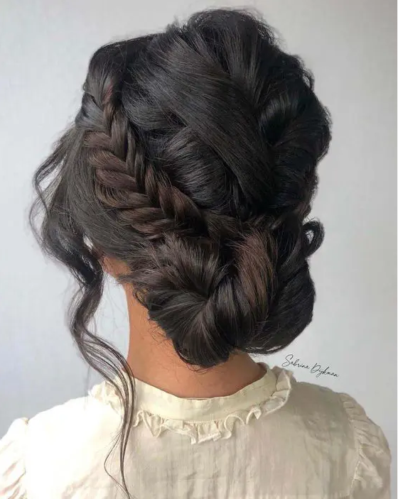 A pretty low twisted updo with a side fishtail braid and face framing hair is cool