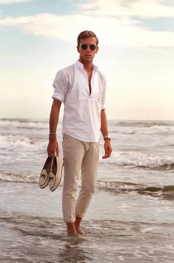 a relaxed and cool beach wedding guest look with a white linen shirt, neutral pants, creamy loafers and sunglasses