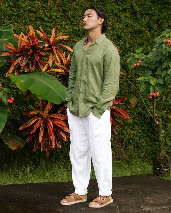 a relaxed tropical or beach wedding guest look with a green linen shirt, white linen pants, brown birkenstocks