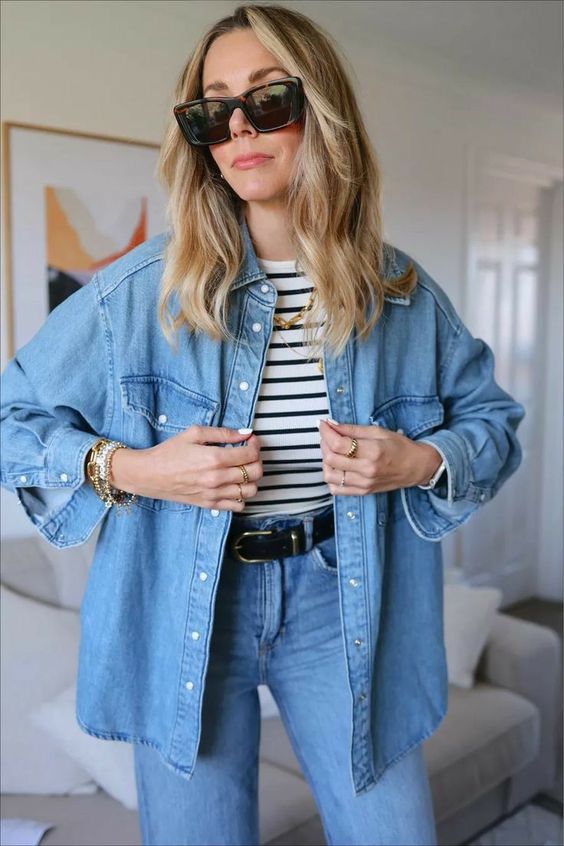 a simple and cool spring outfit with blue jeans, a blue denim shirt, a striped top and cool jewelry