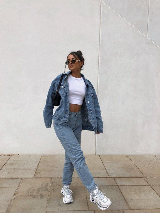 a simple and trendy double denim look with a white crop top, a blue oversized denim jacket and jeans, white trainers