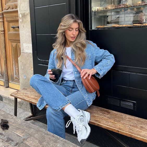 a simple every day look with a white t-shirt, a blue denim shirt, blue jeans, white trainers and socks and a brown mini bag