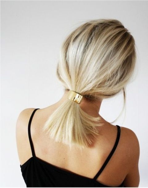a simple low ponytail with a volumetric top accented with a glossy metal accessory is a cool solution, with a bit of chic