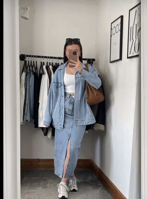 a spring double denim look with a bleached oversized denim jacket and a matching maxi skirt, neutral trainers, a white top and a brown bag