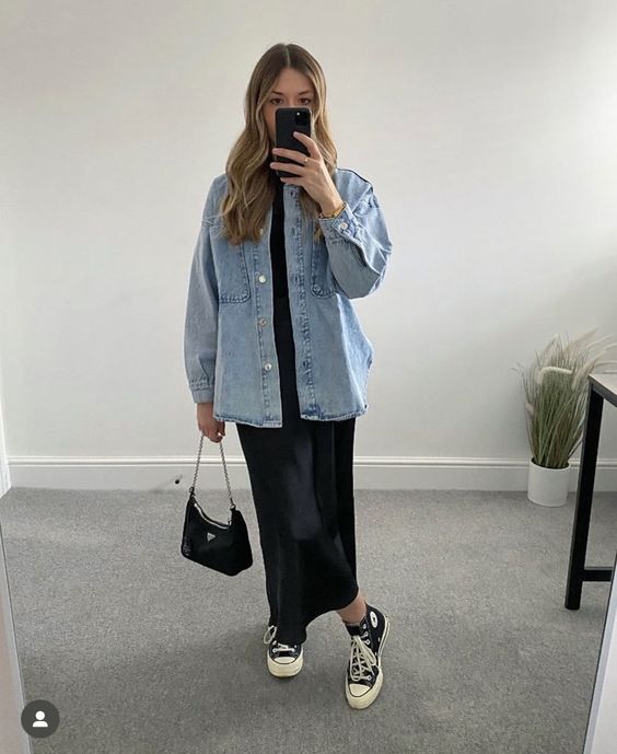 a spring look with a black maxi dress, black high top sneakers, a blue denim shirt and a black bag