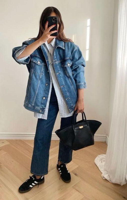 a spring look with a striped button down, a blue oversized denim jacket, navy jeans, black sneakers and a black tote