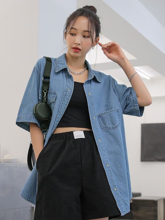 a spring outfit with a black top and pants, a blue denim shirt, a black bag and a chain necklace is cool for summer, too