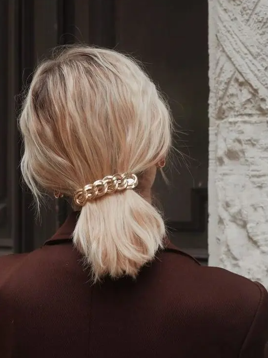 a super simple and quick hairstyle, a wavy low ponytail accented with a chain barette