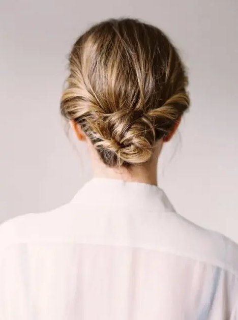 A twisted low bun with a textural top is long lasting lob styling for a bride or bridesmaid