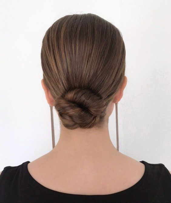 a twisted low bun with a tight and sleek top is a timeless and chic hairstyle for a wedding