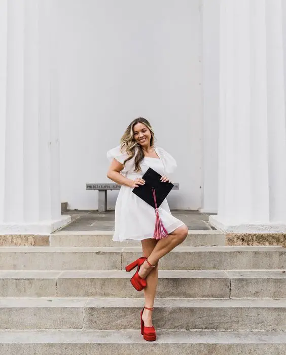 a white mini dress with puff sleeves, a cap and red platform shoes are a cool outfit for graduation