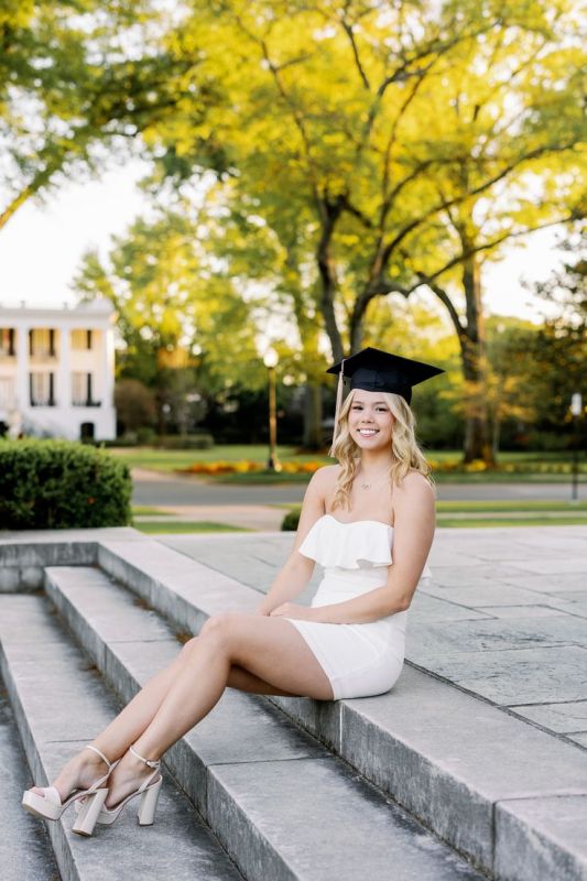 a white mini ruffle neck dress, platform shoes, a black cap are a cool and sexy outfit for graduation