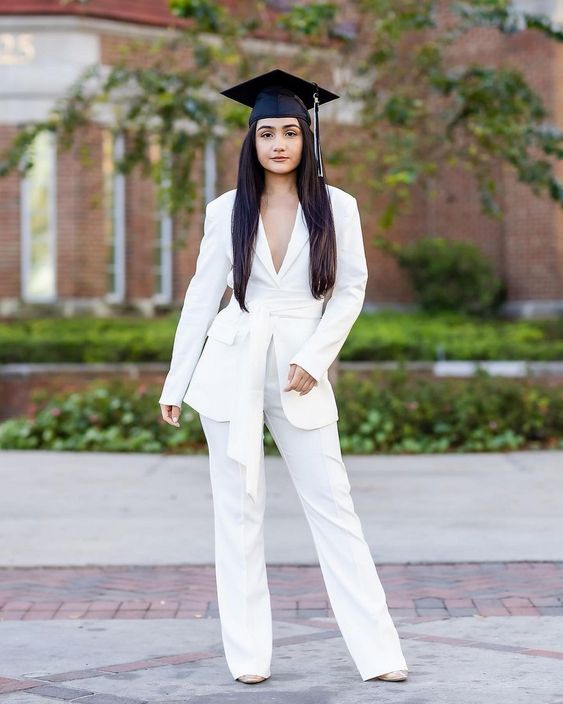a white pantsuit with a sah, nude shoes and a cap are a cool and trendy outfit for any graduation