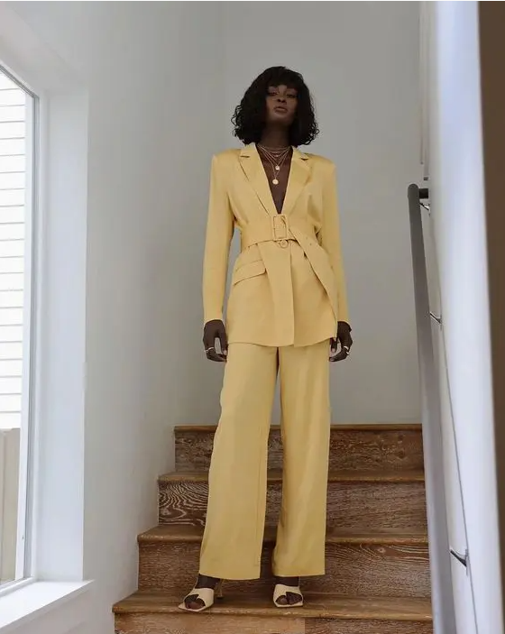 a yellow pantsuit with a belt, layered necklaces, nude shoes and chic rings is a cool idea for spring and summer
