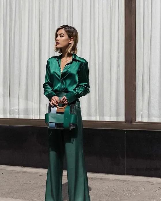 an emerald look with a blouse and flare pants, a stripe bag is a cool and chic idea for a fall wedding
